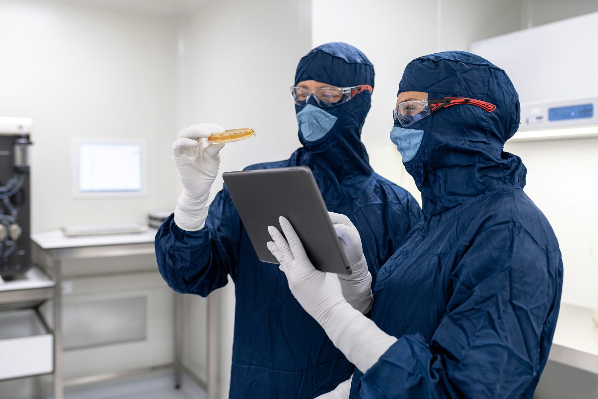 Un par de personas con mascarillas y sosteniendo una computadora portátil.