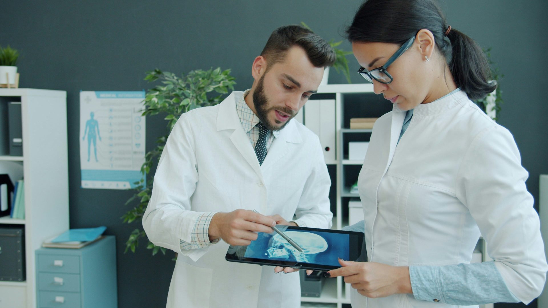 Dos médicos observando una tomografía médica en una tableta.